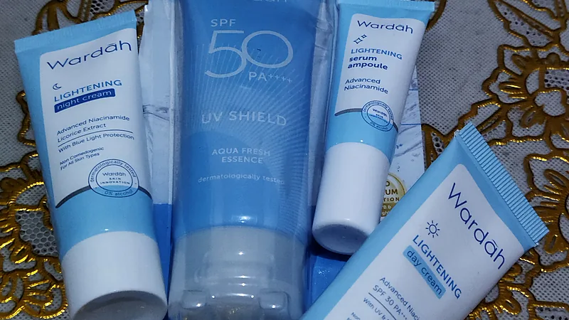 Kemasan produk perawatan wajah Wardah Empat kemasan perawatan wajah Wardah berwarna biru: night cream, day cream, serum ampoule, dan tabir surya SPF 50, tersusun di atas kain putih bermotif